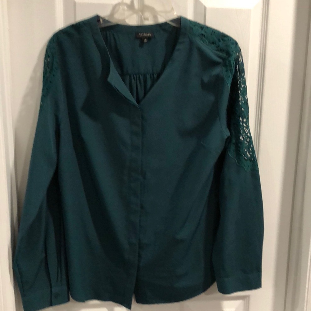 Green blouse with ka e motif on sleeves.